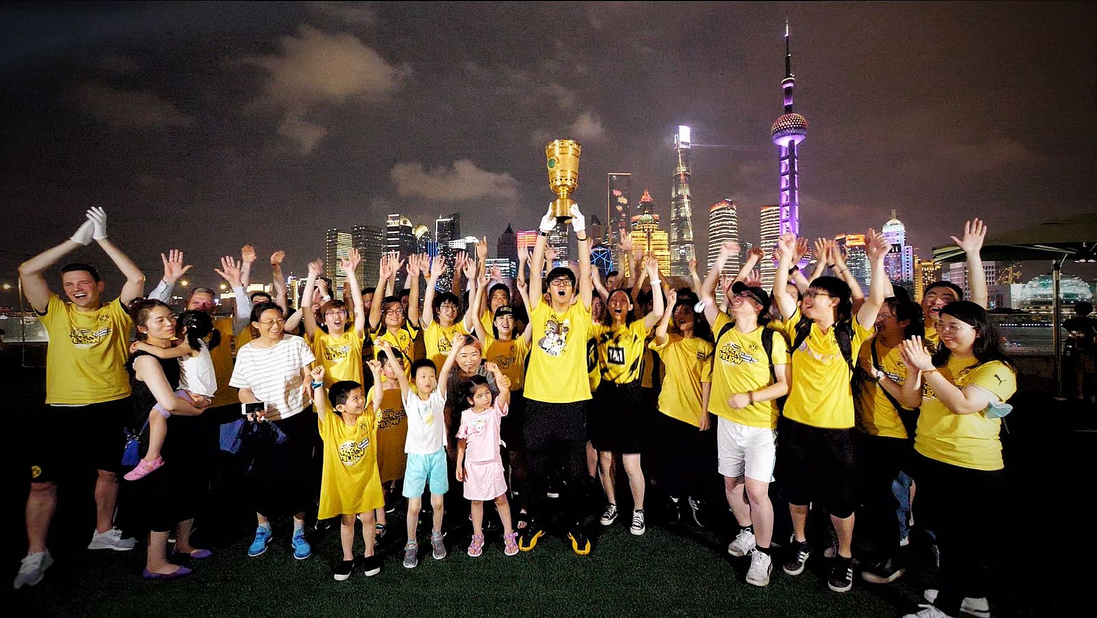 BVB fans holding trophy in front of the Shanghai skyline