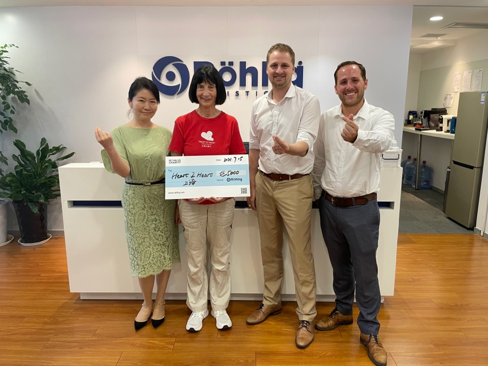 Röhlig staff members hand over a cheque to Heart to Heart in Shanghai